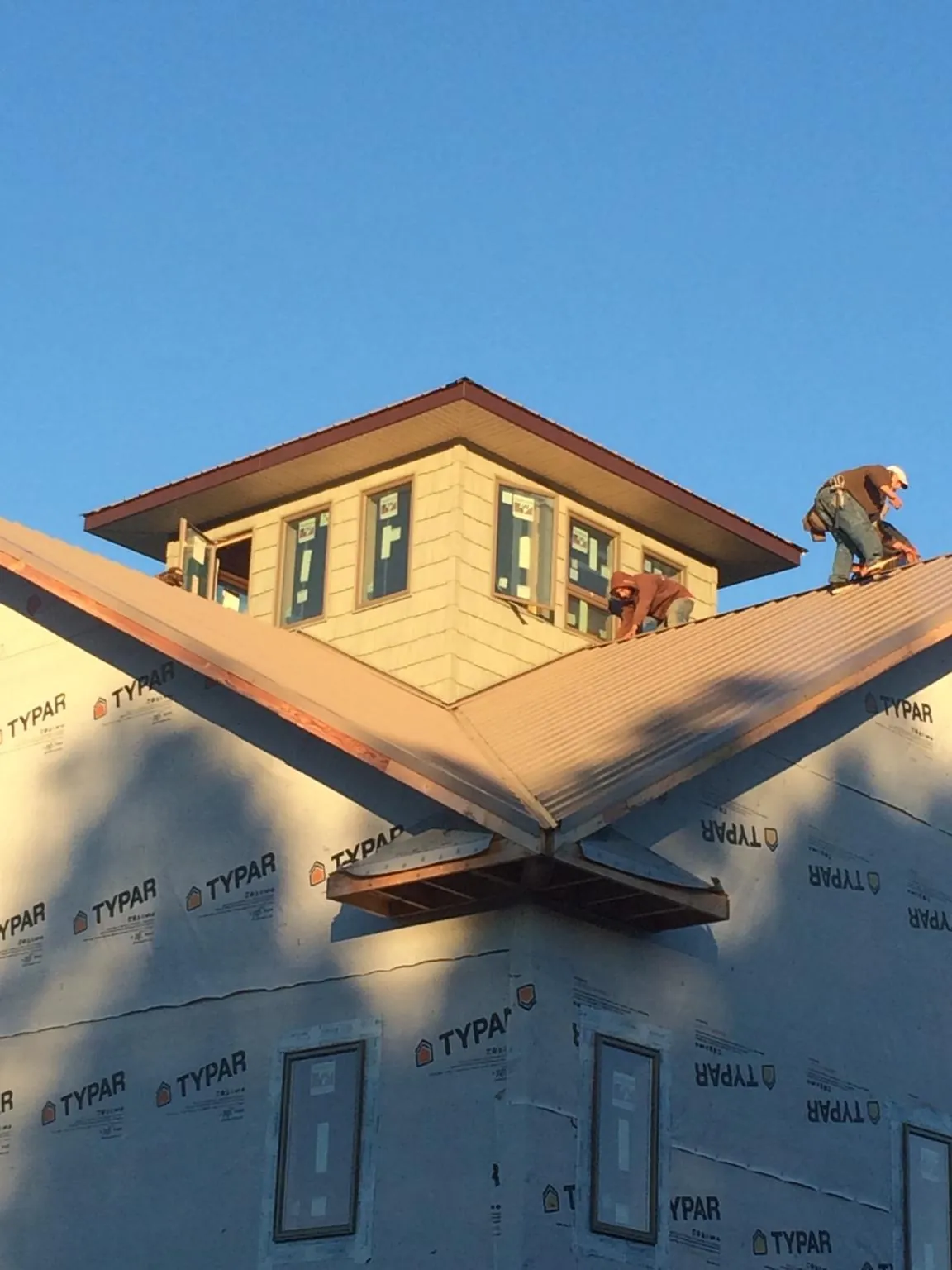 Roofers working around a rooftop cupola on a new metal roof at sunset — Roof Waterproofing in Donald by Roofing Brothers